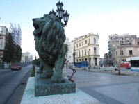 One of Havana's iconic lions along the Prado in central Havana.  In the left background, you can see the National Assembly building modeled after the U.S. Capitol.