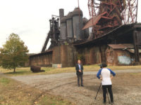 Australian political strategist Bruce Hawker stands in front of a shuttered blast furnace outside Pittsburgh, Pa.  