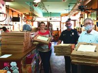 Wappoo Shores resident Julia Sauer, left, carries D'Allesandro's pizzas with Police Chief Luther Reynolds and Mayor John Tecklenburg. Photos by Ruta Smith, Charleston City Paper.